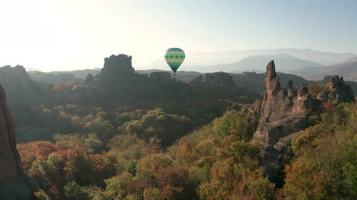 Hot air balloon flying over picturesque rock formation