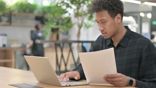 Young Adult Working at Laptop in Modern Office