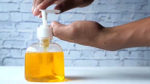Nahaufnahme der Hand eines jungen Mannes mit Desinfektionsgel zur Vorbeugung von Viren