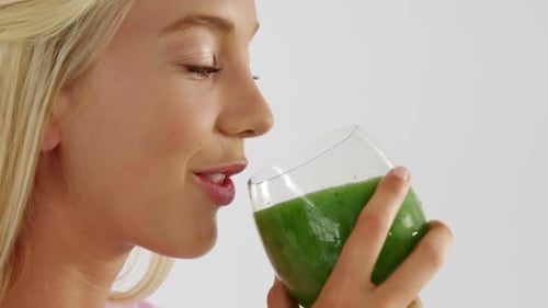 Blonde Woman Drinking Green Smoothie Close Up