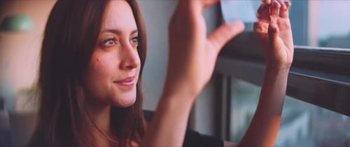 Woman Examining Film Strip by Window