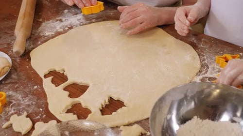 Child and Adult Baking Cookies with Cookie Cutters