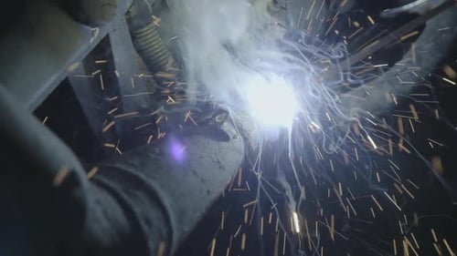 Nahaufnahme eines Metallschweißers, der mit einem Lichtbogenschweißgerät arbeitet.