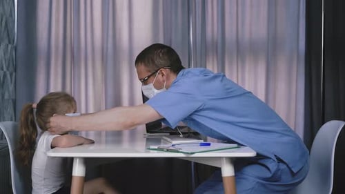 Doctor Puts Protective Mask on Young Child Patient