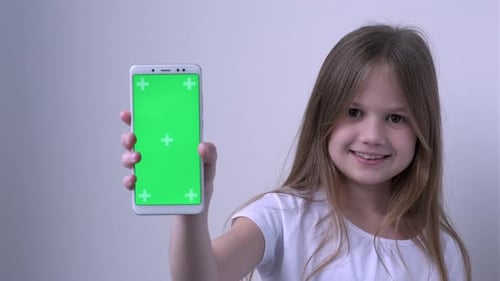 Cute Child Girl Shows Phone with Green Screen Mock Up Cellphone Mobile Telephone