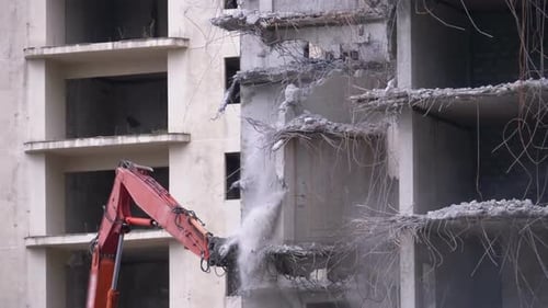 Destroying Old Concrete House Using Mechanical Arm of Bulldozer on Construction Site