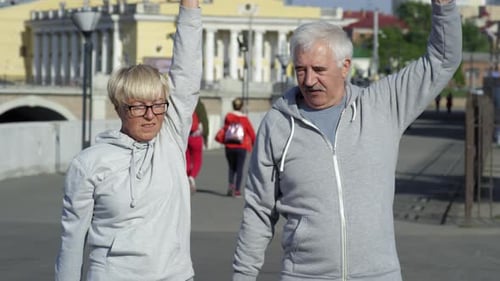 Active Senior Couple Exercising Together in Urban Park