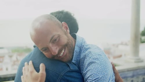 Side View of Happy Gay Couple Sitting and Kissing on Bench