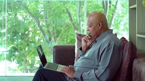 Man Uses Laptop Indoors During Daytime