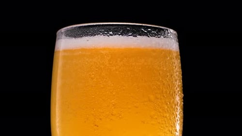 Refreshing Beer in Glass with Condensation and Bubbles