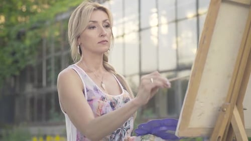 Portrait of Confident Charming Blond Woman with Brown Eyes Painting Landscape Outdoors. Beautiful