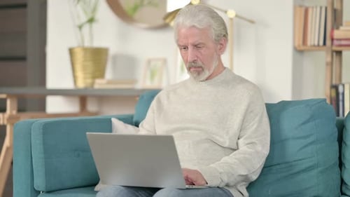Mature Man Using Laptop Computer on Couch