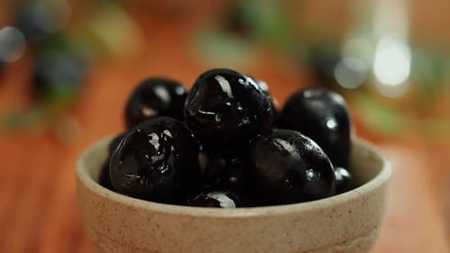 Olive Oil Black Oilves on Brown Background Closeup