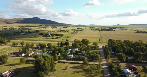 Drone Flying Over Village Houses With Scenery Of Lush Field And Trees. aerial