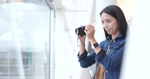 Woman Taking Photo on Camera in Airport