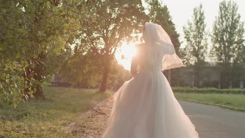 Running Bride in White Wedding Dress on the Road at Sunrise