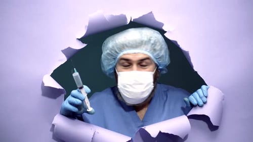 Man in Scrubs Holds Syringe and Looks Around