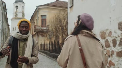 Cheerful Multiethnic Couple Walking in Old Town and Chatting