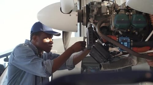 Black Technician Examining Aircraft Engine
