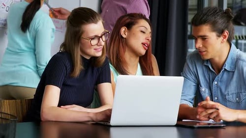 Führungskräfte interagieren, während sie über Laptop diskutieren