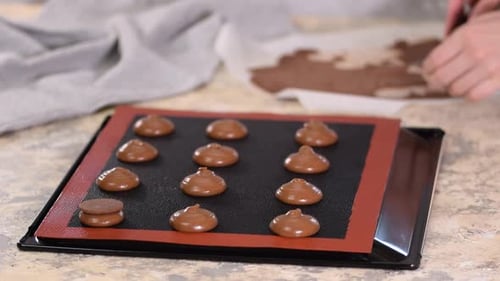 Assembling Delicious Chocolate Macarons on Baking Sheet