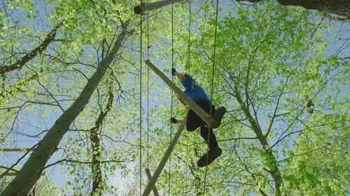 Adult Navigates Rope and Log Obstacle Course