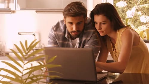 Couple Uses Laptop in Modern Home Kitchen