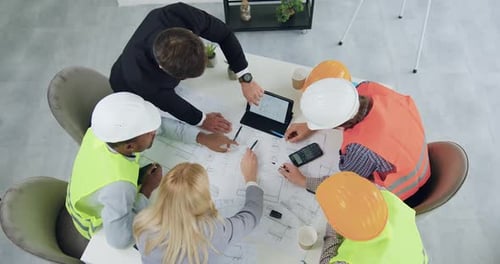 Equipo de constructores y gerentes que celebra una reunión conjunta para aclarar los detalles