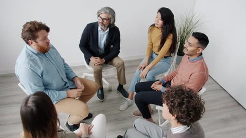 High Angle View of People Citting in Circle Talking and Gesturing During Group Therapy