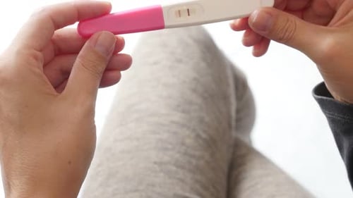 Home pregnancy test holding in female hands 4K 2160p UltraHD tilt footage - Female holding in hands