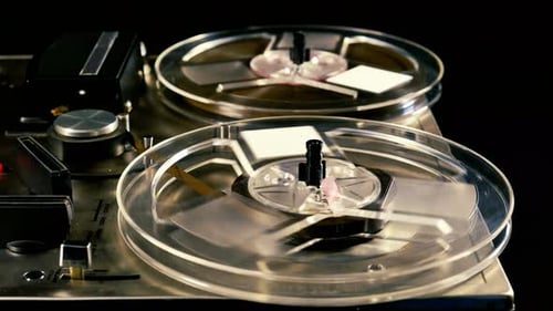 Vintage Reel to Reel tape recorder playing music close up of reel