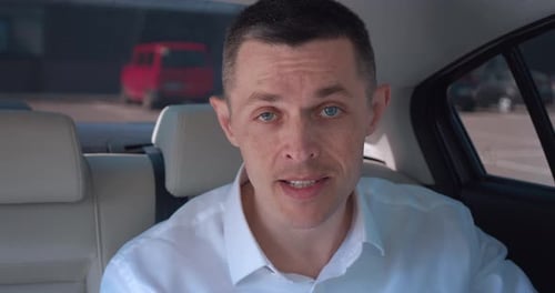 Man Talking in the Back Seat of Car