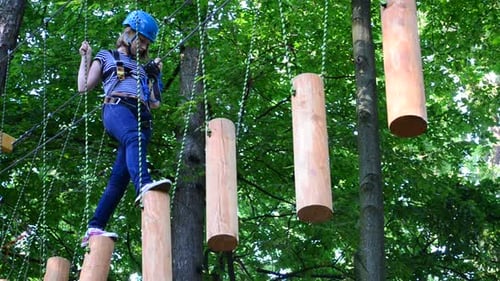 Girl Navigating Rope Course in Forest
