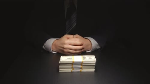 Bribe: Businessman waits and puts a heap money on a table