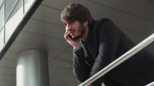 Man Talking on Cellphone outside Modern Building