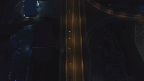 Road Intersection with Roundabout and City Traffic in the Night