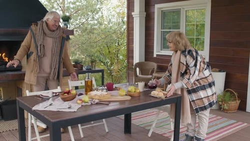 Aged Couple Having Picnic on Outdoor Terrace