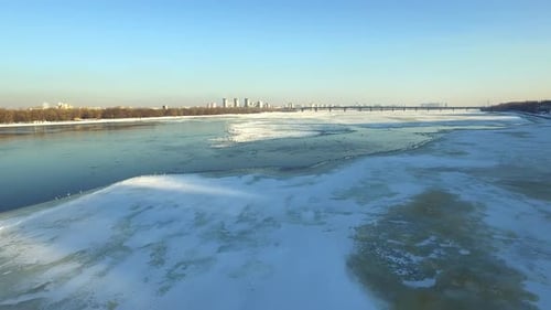 Vista aérea del río congelado en Winter City. Aves volando sobre el río helado
