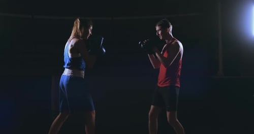 Woman and Man Sparring in Boxing Ring
