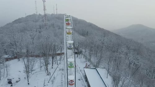 Ferris Wheel on Top of Mount Akhun During a Snowfall