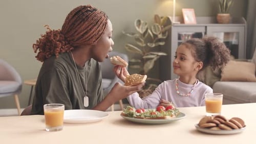 Woman Feeds Child Sandwich Slice Indoors