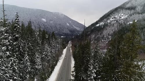 Treetop Frost Forest View SUV-Fahrzeug fährt den verschneiten Berg Highway hinunter