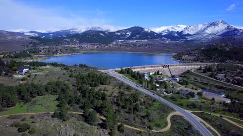 Panoramic aerial view over the Navacerrada Reservoir with the beautiful snow-capped mountains on the