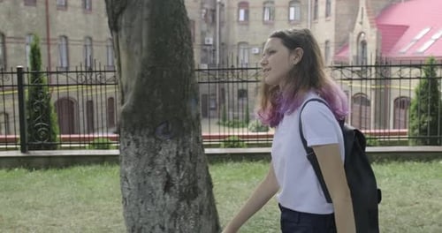 Teenage Girl Walking to School in Urban Park