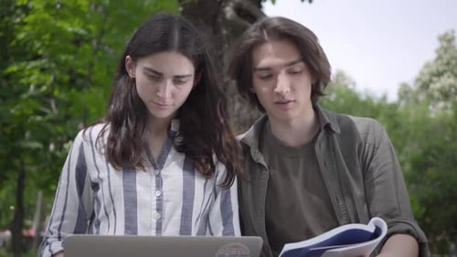Portrait Happy Couple Spending Time Together in the Park, Studying. The Male and Female Students in