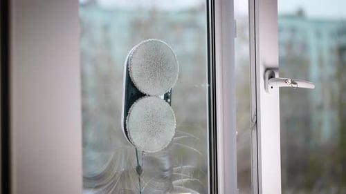 Der automatische Roboterassistent wäscht das Glas des Fensters