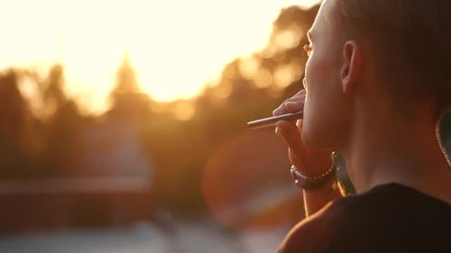 Guy Smokes an Electronic Cigarette Blows Smoke