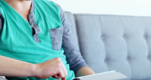 Man Relaxing at Home Using Tablet Device
