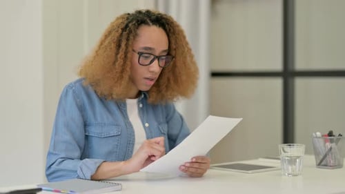 Excited Woman Reading Document in Office