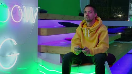 Man Plays Video Game in Neon Lit Setting
